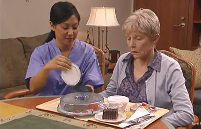 Health care provider assiting a patient with eating a meal