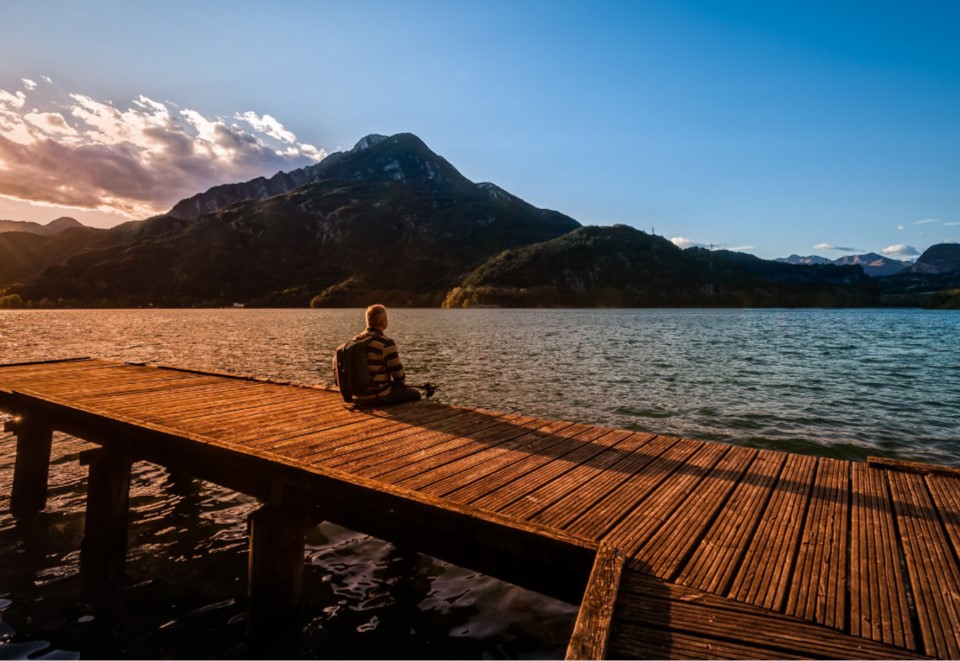 A person sitting on a pier with the words multi-setting peaceful mind a manual to aid in managing anxiety in Veterans with memory impairment