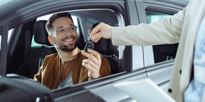 Man receiving key to his new car