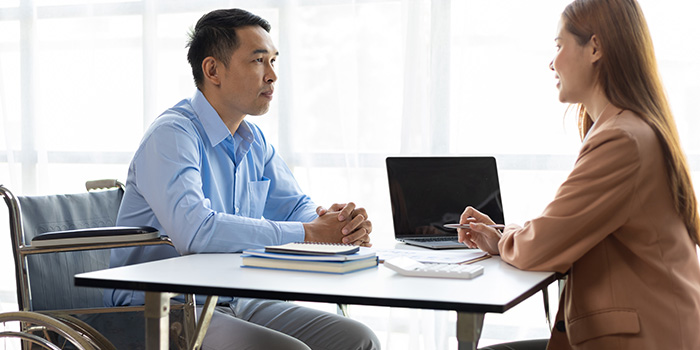 Man in a wheelchair reviewing financial options with a counselor