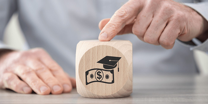 Graduation cap and money wooden block