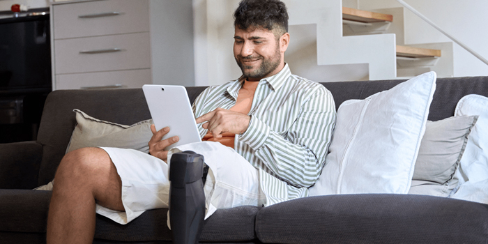 Man with prosthetic leg using a tablet to talk to VA counselor