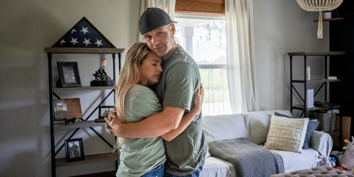 Veteran and daughter hugging in their home