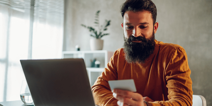 Man in front of computer looking at business card