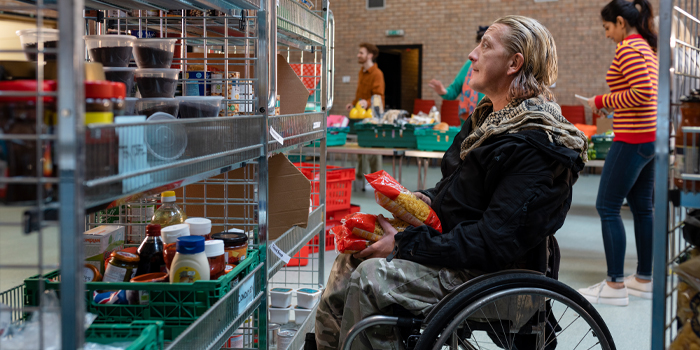 Woman in a wheelchair getting essentails from a community pantry