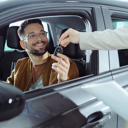 Man receiving key to his new car