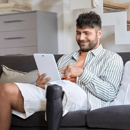 Man with prosthetic leg using a tablet to talk to VA counselor