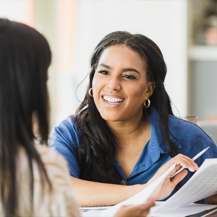 Two women reviewing financial progress and looking happy