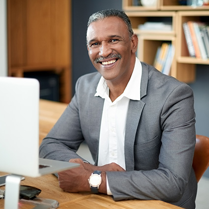 Veteran benefit counselor smiling behind a computer