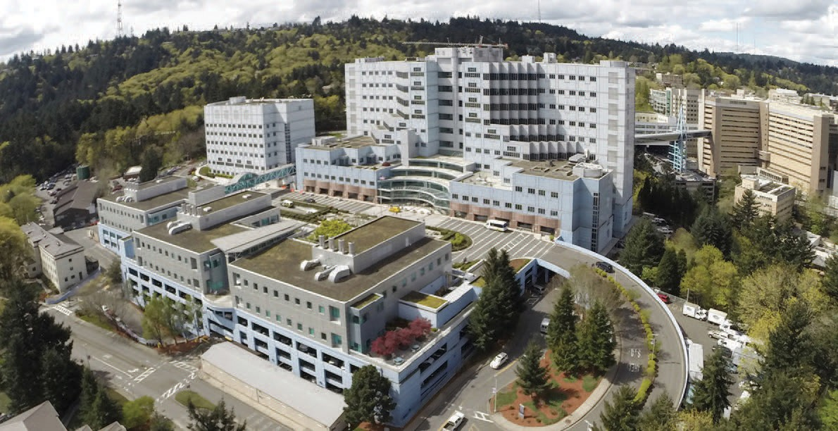 The Portland Veterans Affairs Medical Center campus sits on a 450-foot-tall basalt-rock hill south of downtown. In 1987, VA expanded PVAMC and built a skybridge with federal funding secured by Senator Mark Hatfield. The 660-foot-long skybridge allows direct transportation of patients and supplies between PVAMC and OHSU over a 150-foot-deep ravine.