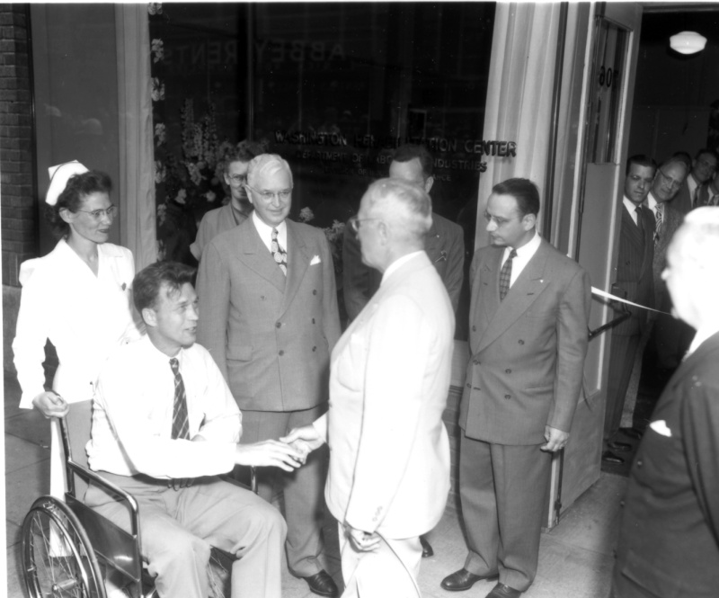 President Harry S. Truman shakes hands with a young man in a wheelchair at the Veterans' Hospital in Seattle, Washington. From: Naval Photo Center
