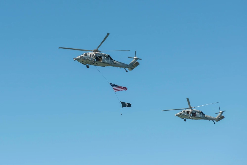 SAN DIEGO (Sept. 18, 2015) An MH-60S Sea Hawk assigned to Eightballers of Helicopter Sea Combat Squadron (HSC) 8 flyby carrying the national ensign and a POW/MIA flag during a national POW/MIA Remembrance Day ceremony hosted by the guided-missile cruisers USS Stockdale (DDG 106) and USS William P. Lawrence (DDG 110). Stockdale and William P. Lawrence are named in honor of two POWs who served with exemplary courage and honor during their captivity in North Vietnam. (U.S. Navy photo by Mass Communication Specialist 2nd Class Phil Ladouceur/Released)